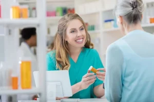 pharmacy tech helping out female patient behind the counter