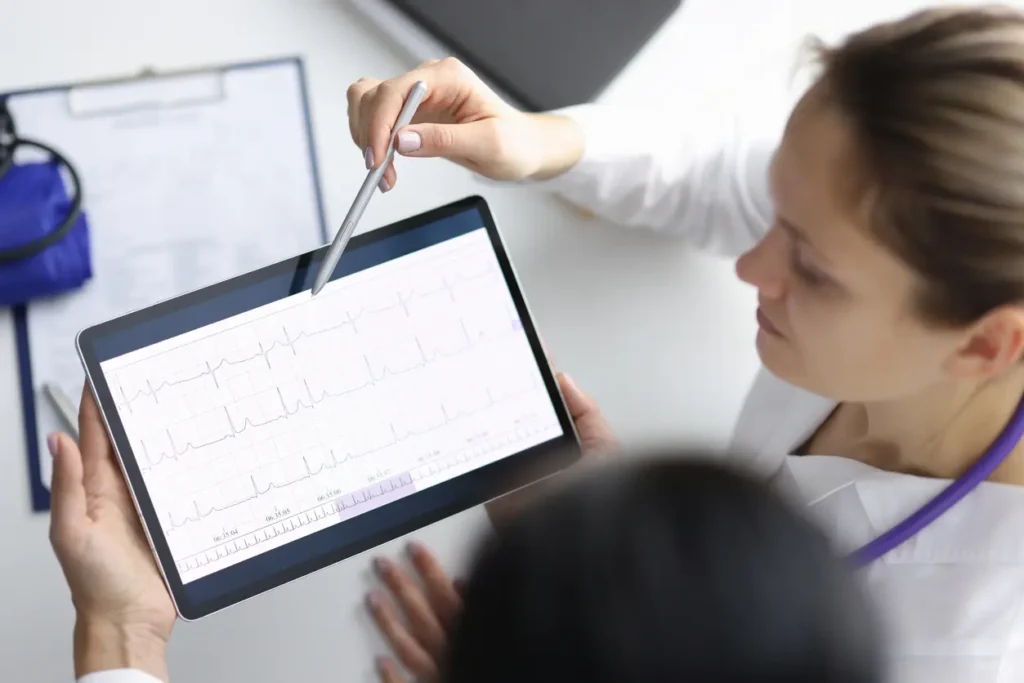 a woman point to an Ipad of a health graph to another person