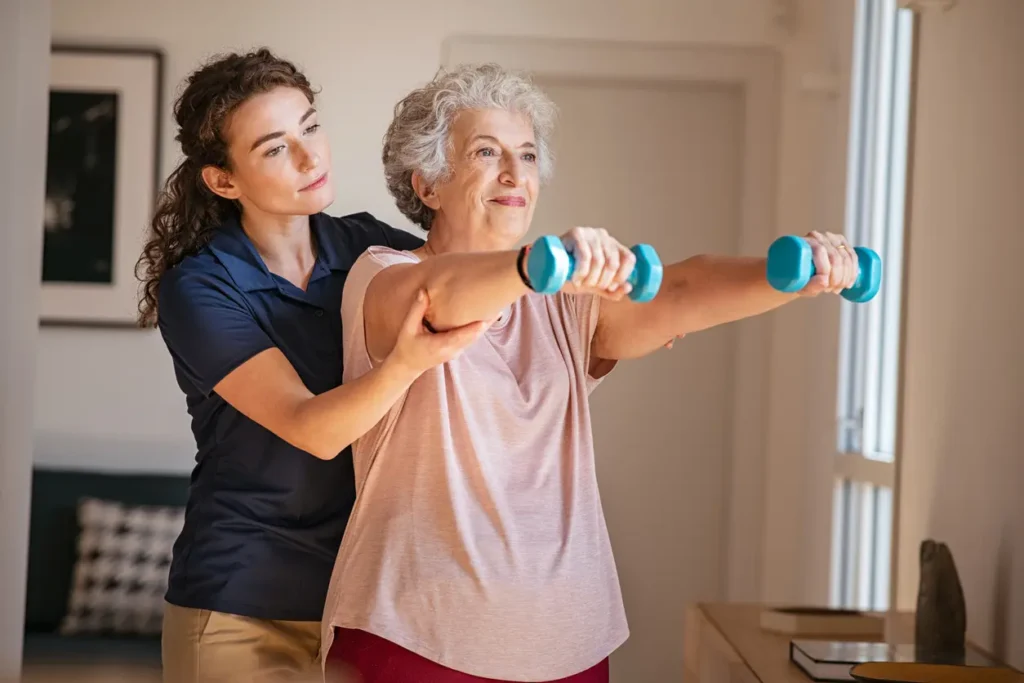 Physical Therapy aide helping women doing weight exercises.