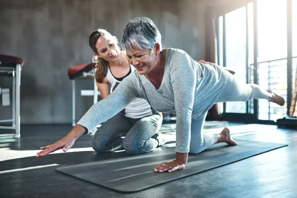 Physical Therapy Aide with women stretching on floor.