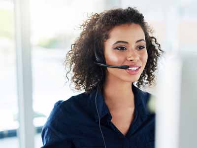 Women talking on headset in front of computer